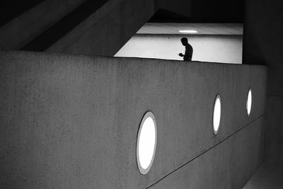 Man using phone in illuminated building