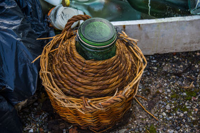 Vintage green glass flask covered with wicker on the street