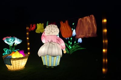 Illuminated lanterns hanging against black background