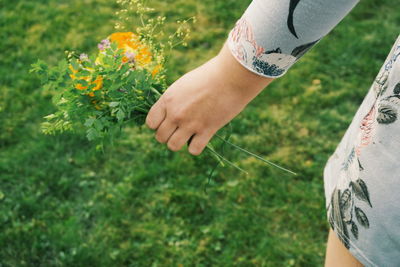 Midsection of woman holding flowers bouquet