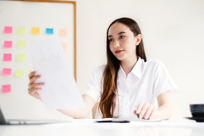 Portrait of young woman using laptop on table