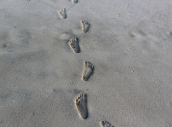 High angle view of footprints on sand at beach