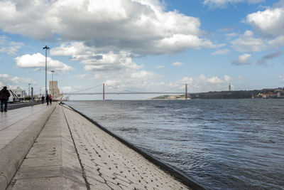 View of bridge over sea against cloudy sky