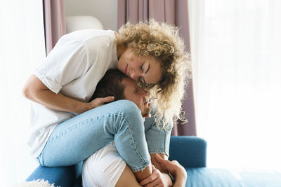 Side view of couple embracing at home