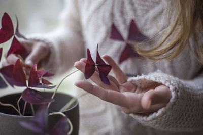 Midsection of woman touching plant