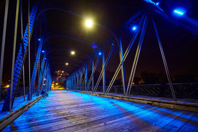 Illuminated bridge against sky at night