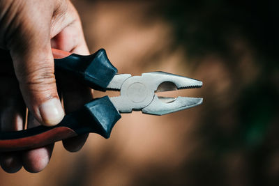 Close-up of man holding pliers