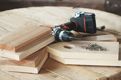 Wooden blanks for a birdhouse and a cordless screwdriver lie on a wooden table. diy concept.