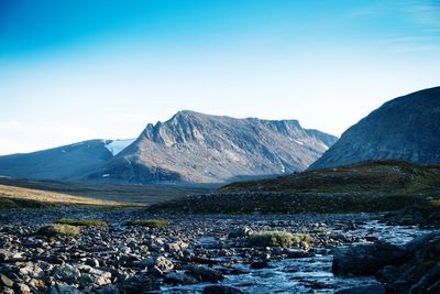 Scenic view of mountains against blue sky