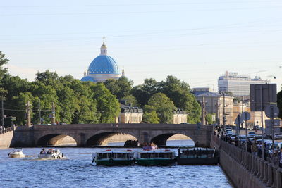 Bridge over river in city against clear sky