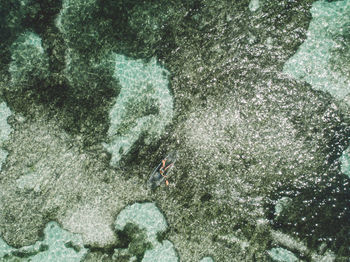Aerial view of woman in inflatable boat on sea