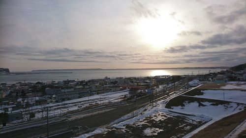 High angle view of cityscape by sea against sky