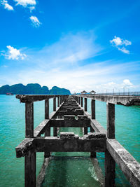 Pier over sea against blue sky