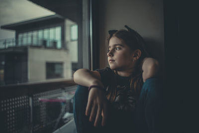 Young woman sitting in window