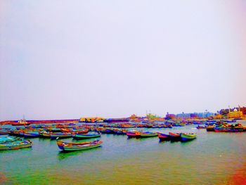 Boats moored in river against clear sky