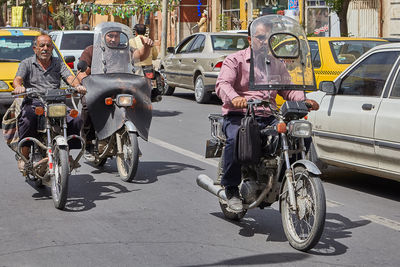 People riding bicycles on street in city