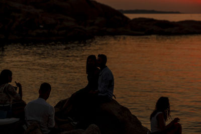 People sitting on beach during sunset