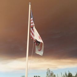 Low angle view of american flag against sky during sunset