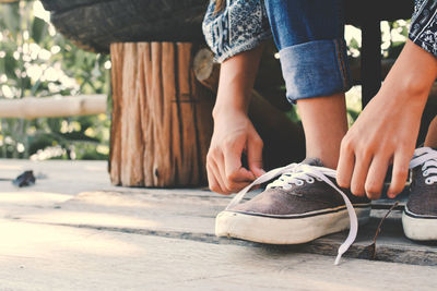 Low section of woman tying shoelace