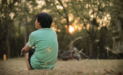 Rear view of man on field in forest