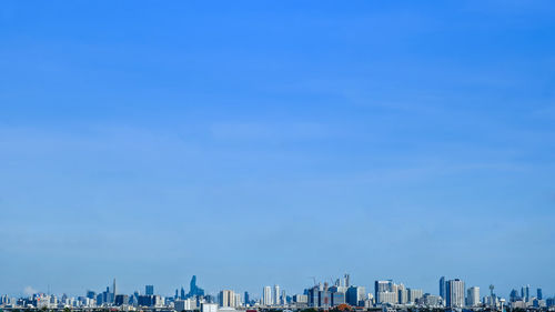 Panoramic view of buildings against blue sky