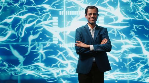 Portrait of businessman standing in swimming pool