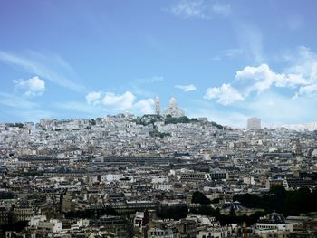 Distance view of basilique du sacre coeur with cityscape against sky