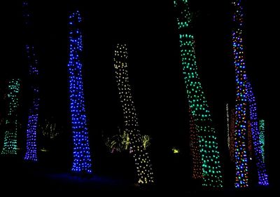 Low angle view of illuminated christmas lights against sky at night