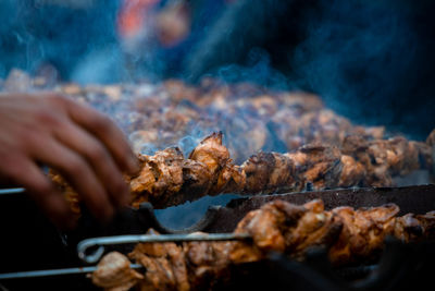 Close-up of person hand on barbecue grill