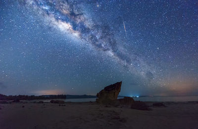 View of star field over beach at night