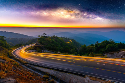 High angle view of light trails on mountain road against sky at night