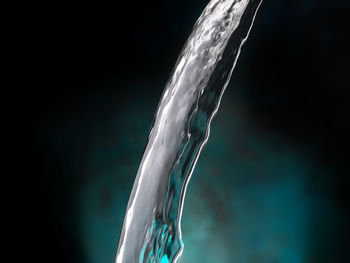 Close-up of icicles on sea against black background