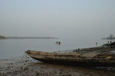 Boat moored on sea against clear sky