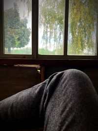 Man relaxing by window at home