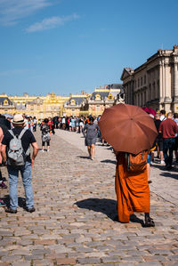Rear view of people on street against buildings