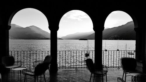 Chairs and table by sea against sky