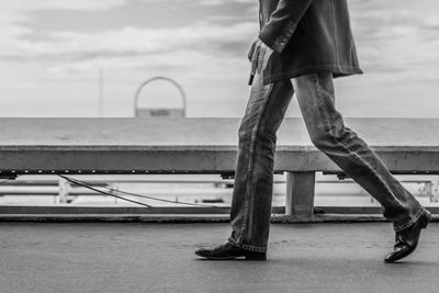 Low section of man standing on bridge over river