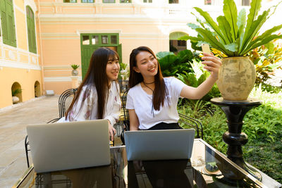 Young woman taking selfie while sitting outdoors