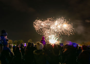 People watching firework display at night