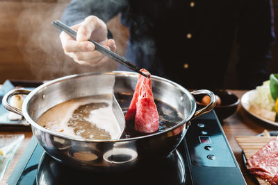 Midsection of man preparing food in kitchen