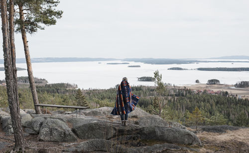 Woman standing on a rock enjoying the beautiful view in sweden