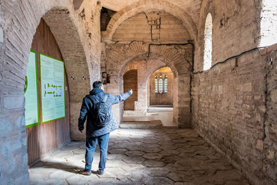 Rear view of man walking in corridor of building