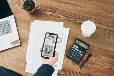 Woman scanning qr code from invoice to make payment using payment app on smartphone. qr scanner