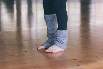 Low section of woman standing on hardwood floor