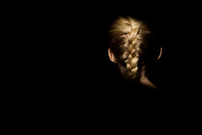 Blonde girl braid in light with dark background