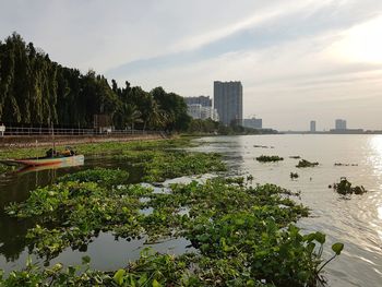 Scenic view of lake by buildings against sky