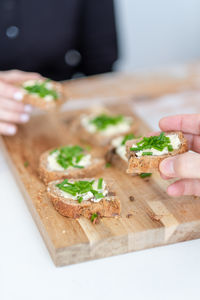 Close-up of hand holding food on cutting board