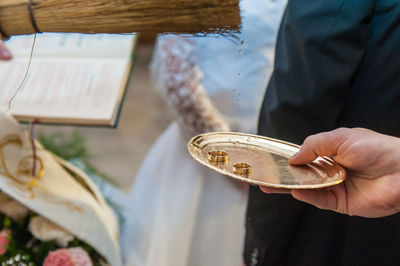 Cropped hand of person holding rings in plate