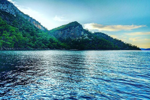 water, mountain, tranquil scene, scenics, waterfront, tranquility, beauty in nature, sky, rippled, nature, sea, idyllic, mountain range, lake, blue, tree, cloud, non-urban scene, cloud - sky, outdoors