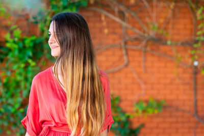 View of smiling young woman looking away standing outdoors